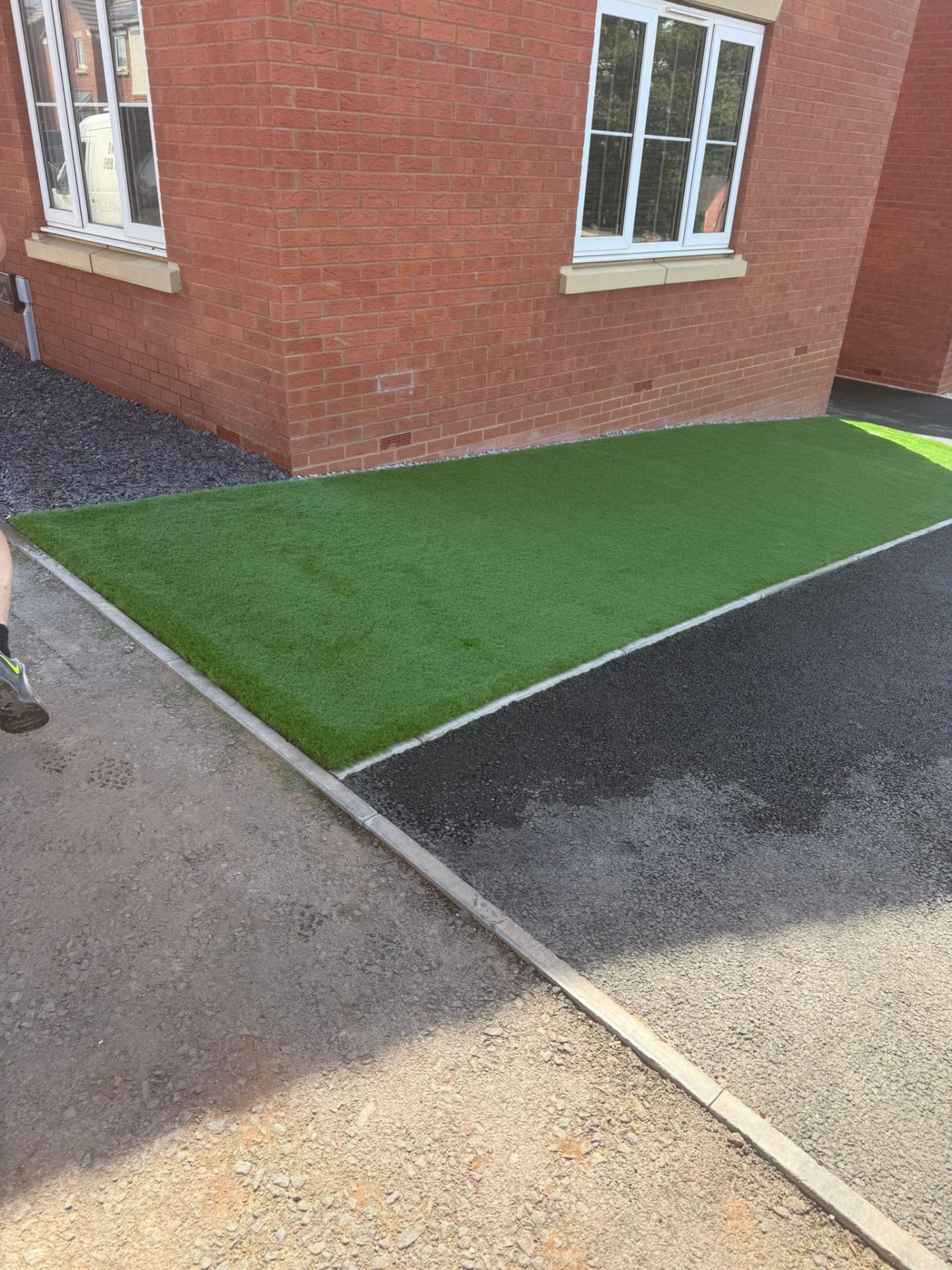 Artificial grass area with kerb edging and fresh tarmac driveway — Shropshire installation