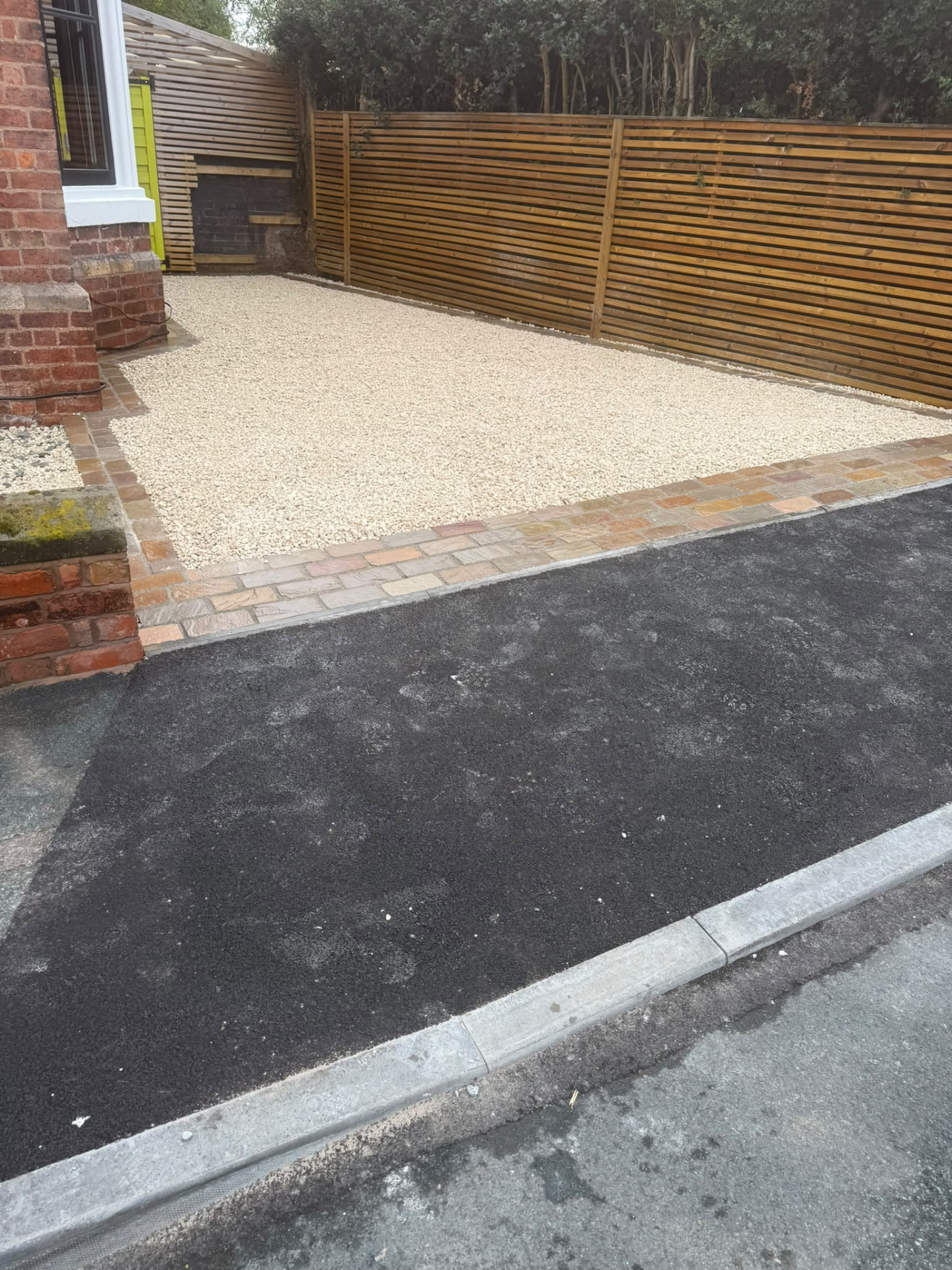 Cream gravel driveway with sandstone cobble edging, new tarmac apron and slatted timber fencing — Shrewsbury