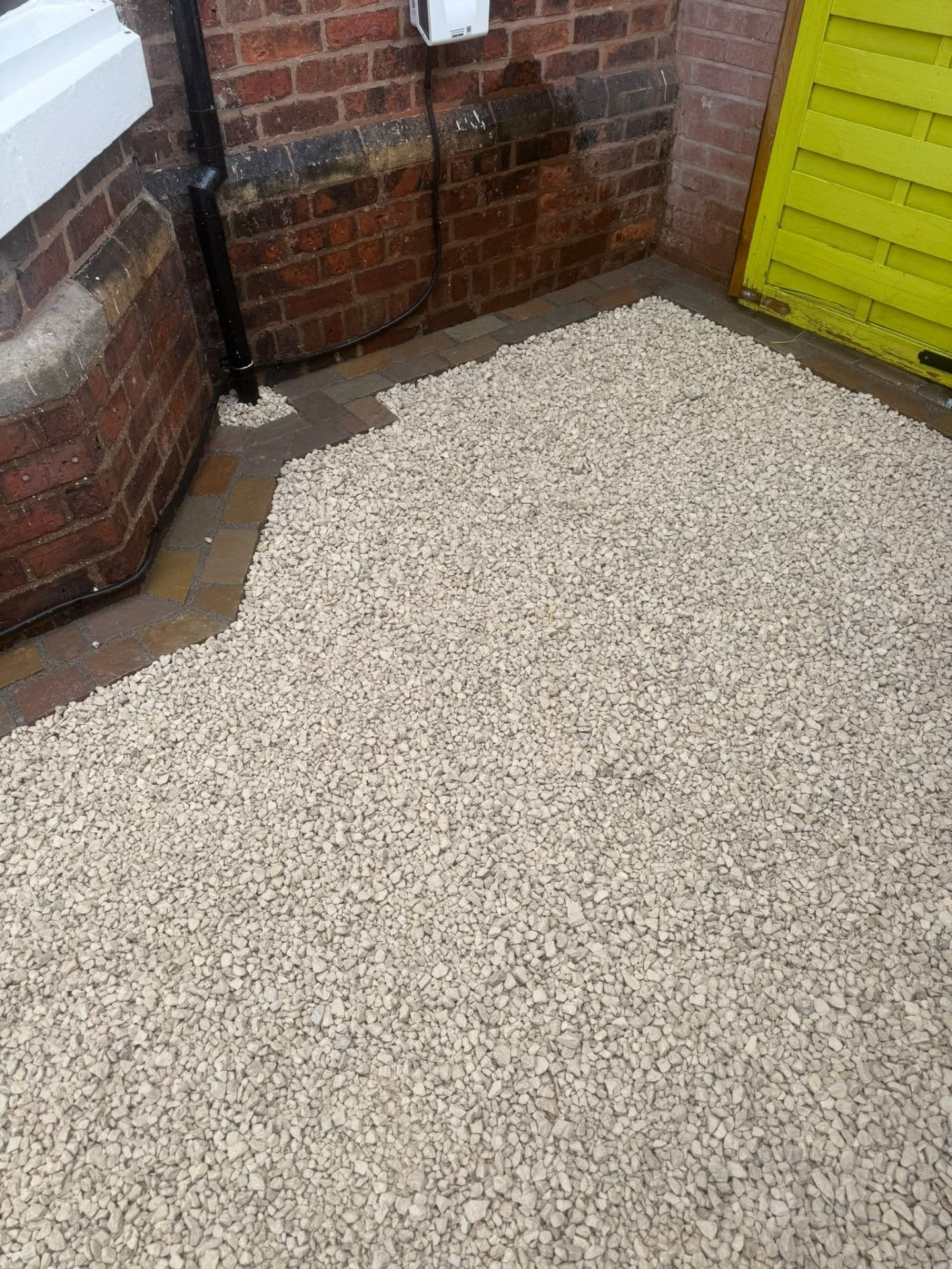 Gravel front garden with sandstone cobble border shaped around the house — Shropshire